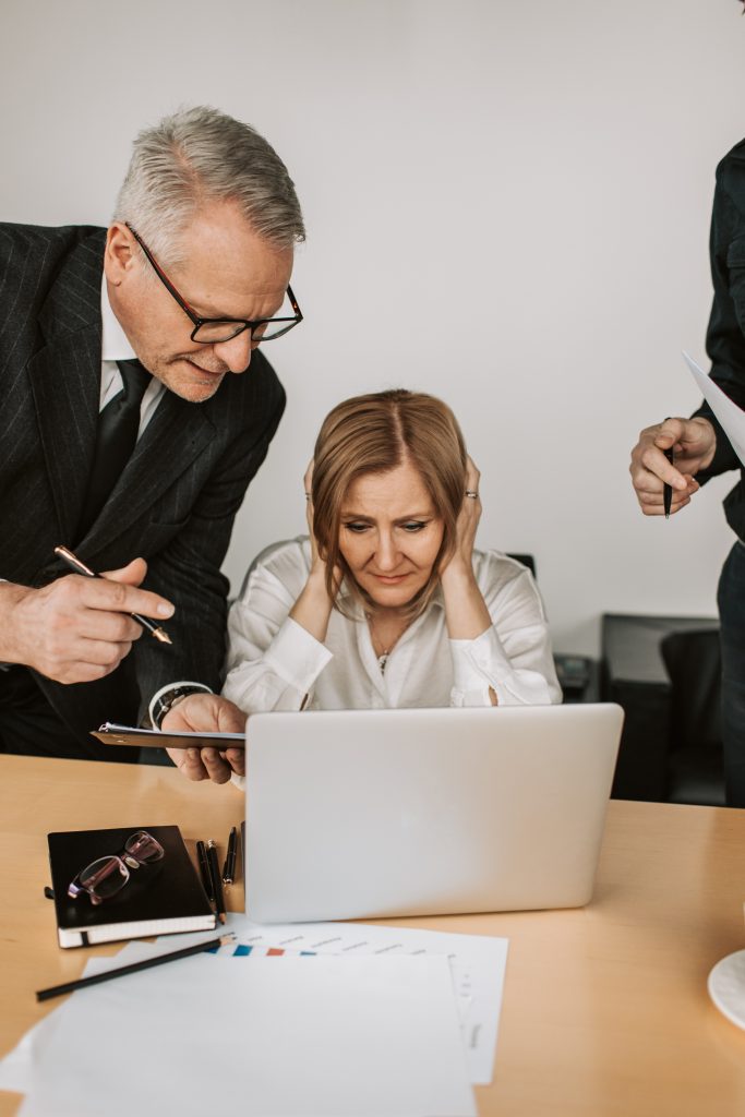 Women leaders The Great Break Up - Image shows stressed out woman in a corporate work environment